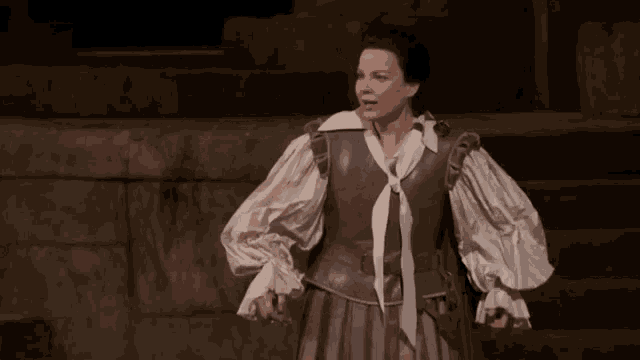 a woman in a costume with ruffled sleeves and a gray vest