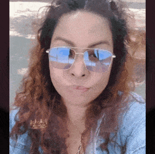 a woman wearing sunglasses has a crown on her ear