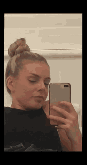 a woman is taking a picture of herself in a mirror .