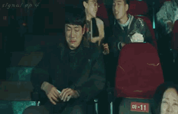 a man is sitting in a red seat with a sign that says 01-11