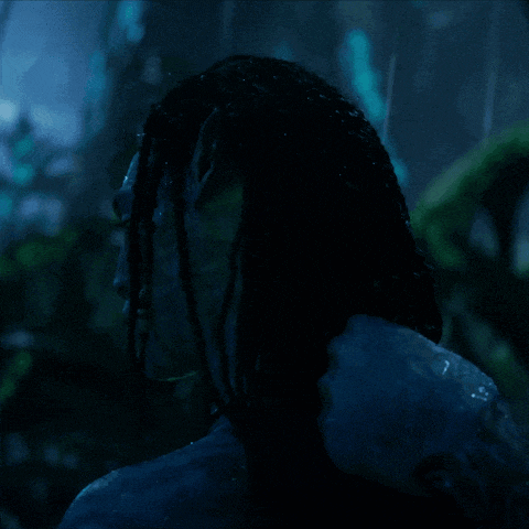 a close up of a person 's face with dreadlocks in the dark
