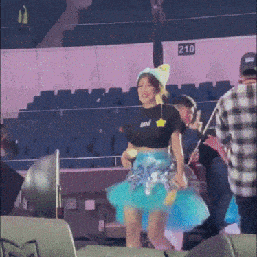 a girl wearing a blue tutu and a black shirt that says ben on it