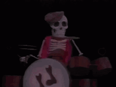 a skeleton is playing drums in a dark room with a knife in his hand .
