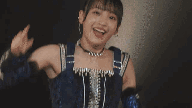 a girl in a blue dress is giving the peace sign