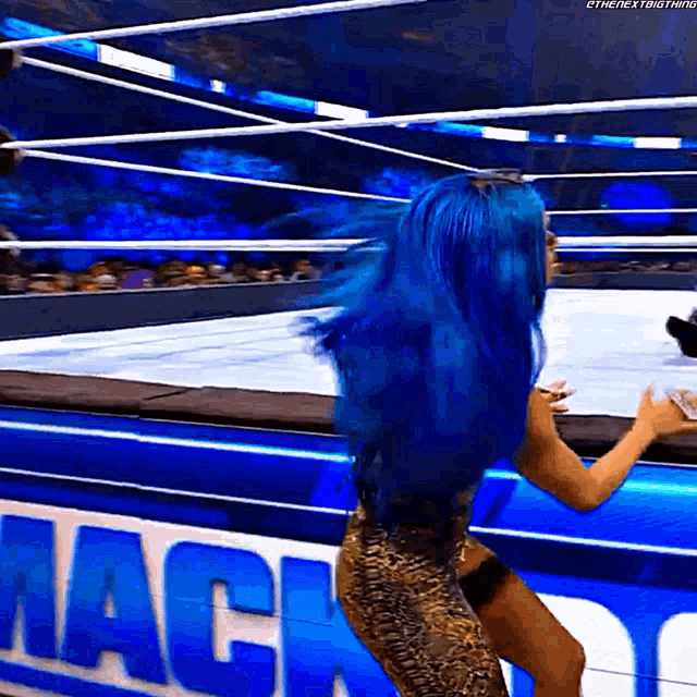 a woman with blue hair is standing in front of a sign that says mack