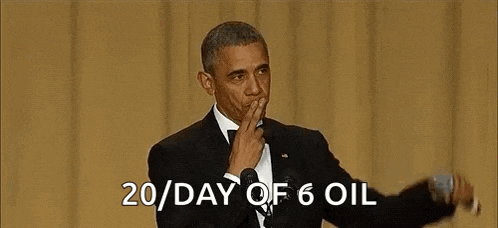 barack obama is giving a speech in front of a microphone while covering his mouth .