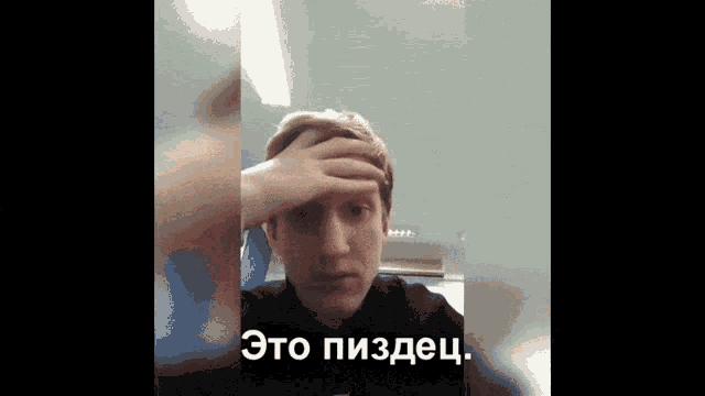 a man holds his hand to his forehead with the words " это пиздец " written below him