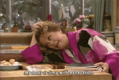 a woman in a pink robe is laying on a kitchen counter with her head on her hand .