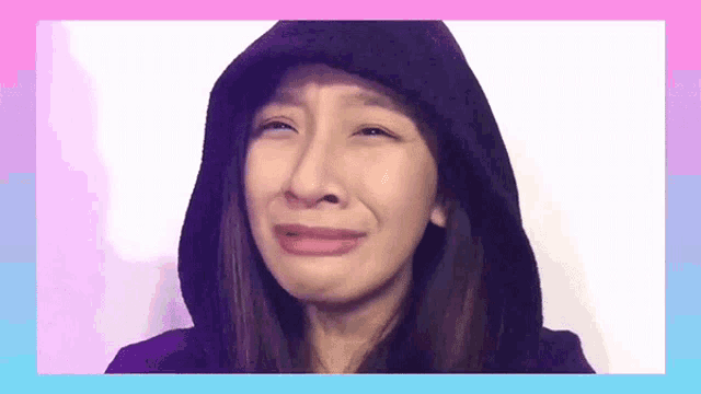 a woman wearing a hooded jacket is crying .