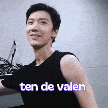 a man wearing a black tank top with the words ten de valen on it