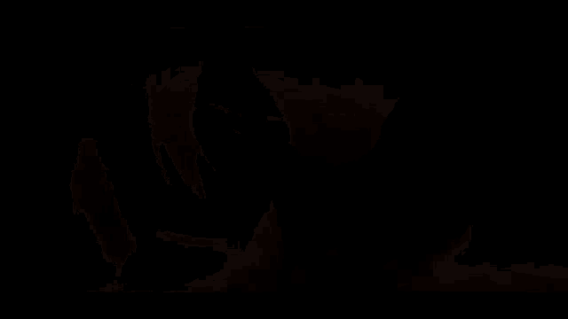 a close up of a person 's face in a dark room with a blurred background .