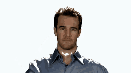 a man in a blue shirt is making a funny face with his hand