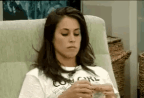 a woman wearing a cowgirl shirt is sitting in a chair with her eyes closed