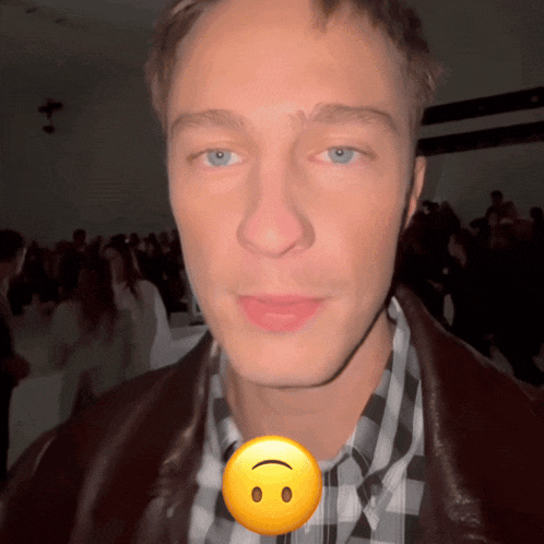 a close up of a man 's face with a yellow smiley face behind it