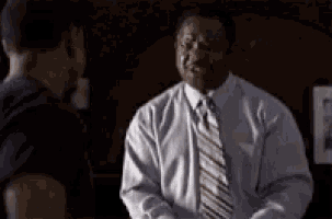 a man in a tie is talking to another man