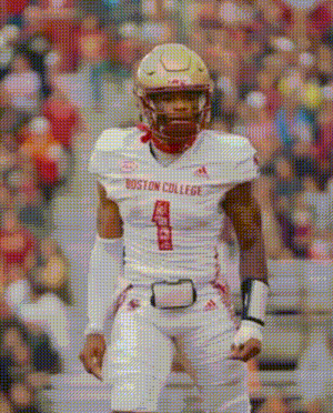 a boston college football player wearing number 1 stands on the field