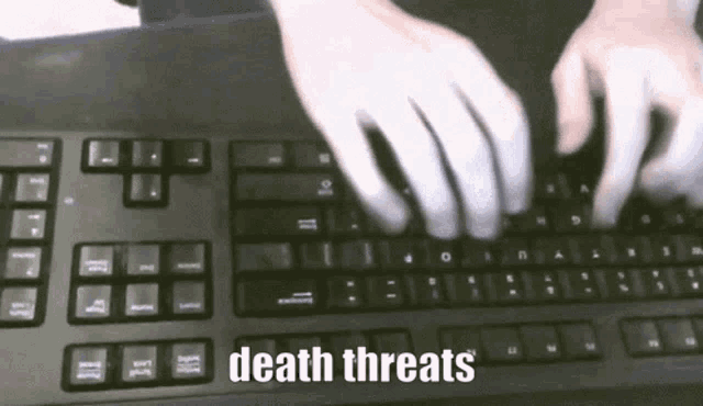 a person is typing on a keyboard with the words death threats written below them