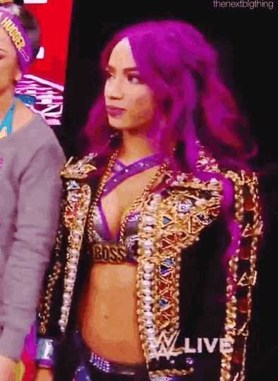 a woman with purple hair is standing in front of a sign that says wwe live .