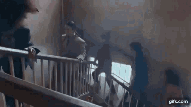 a group of people are walking down stairs in a building .