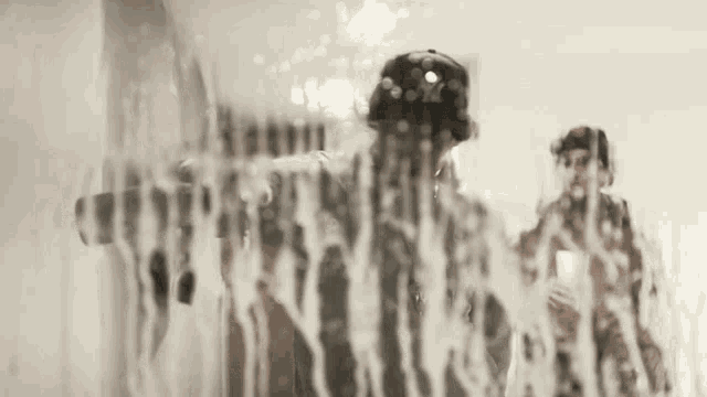 a man in a baseball cap is standing in front of a shower