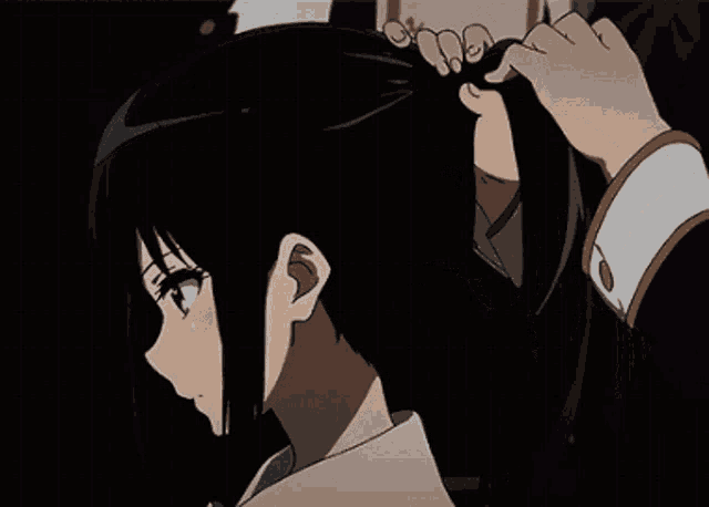 a person is tying a girl 's hair in a ponytail