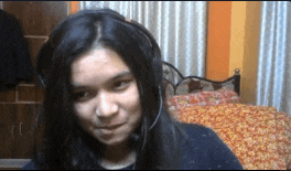 a girl wearing headphones looks at the camera and smiles