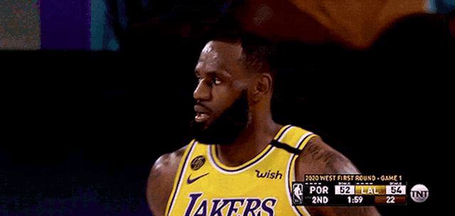 a basketball player wearing a lakers jersey looks at the camera
