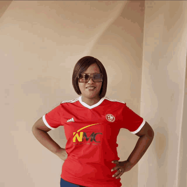 a woman wearing a red shirt that says nmc on the front