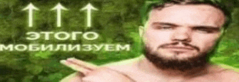 a shirtless man with a beard is pointing at something in front of a green background .