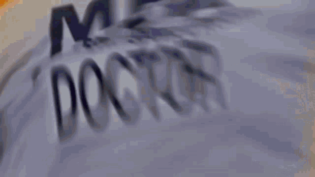 a blurred image of a man running with the word doctor on his back