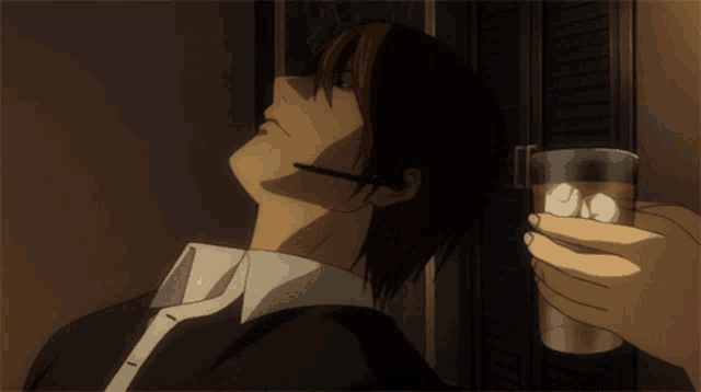 a man in a suit and tie is holding a glass of whiskey