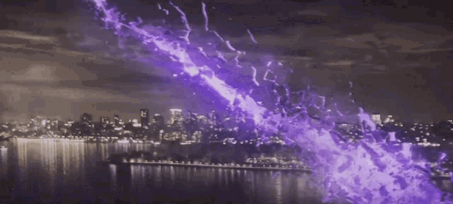 a purple light is coming out of the sky over a city