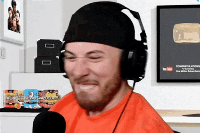 a man wearing headphones is making a funny face in front of a sign that says congratulations