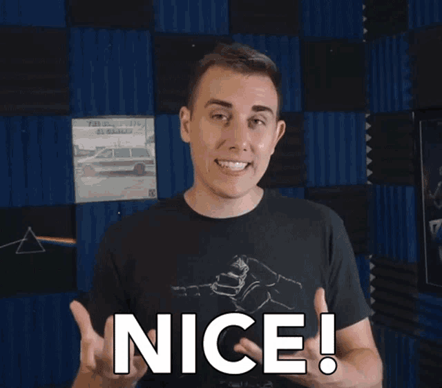 a man in a black shirt says nice in front of a blue wall