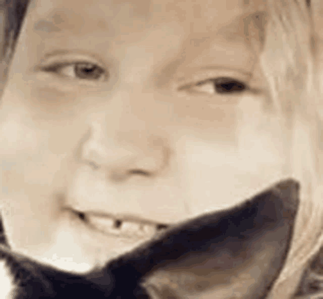 a close up of a young girl holding a cat 's ear .