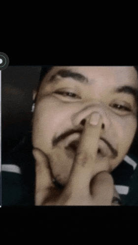 a man with a mustache covering his mouth with his hand