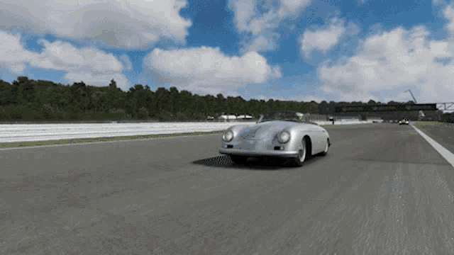 a silver sports car is driving on a track