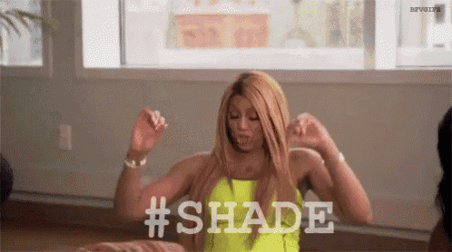 a woman in a neon yellow top is dancing in a room with the word shade written on the screen .