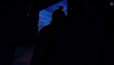 a man is standing in front of a stage with a w logo on the bottom right corner