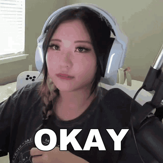 a woman wearing headphones and a shirt that says okay on it
