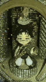 a stuffed animal with a snake around his neck is surrounded by rhinestones