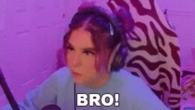 a girl wearing headphones is sitting in front of a computer and says bro .