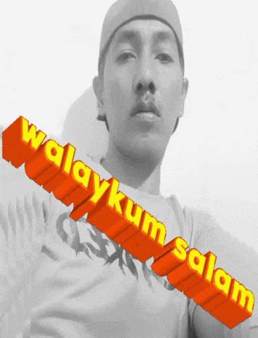 a man wearing a hat and a t-shirt that says ' walaykum salam ' on it