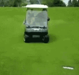 a man is driving a golf cart with a woman sitting on the back
