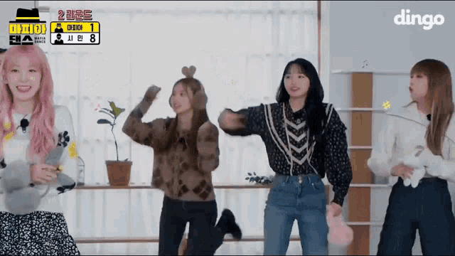 a group of girls are dancing in front of a dingo logo