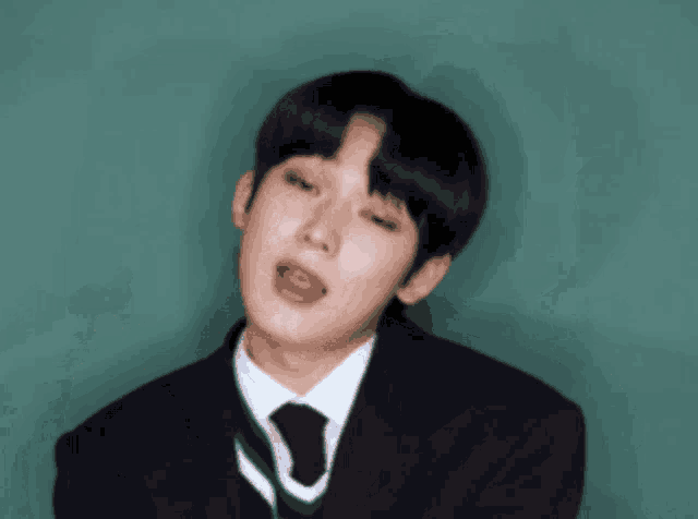 a young man in a suit and tie is making a face