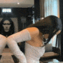 a woman in a white dress and white gloves is standing in a room .