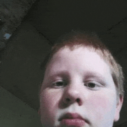 a close up of a young boy 's face with a serious look on his face .