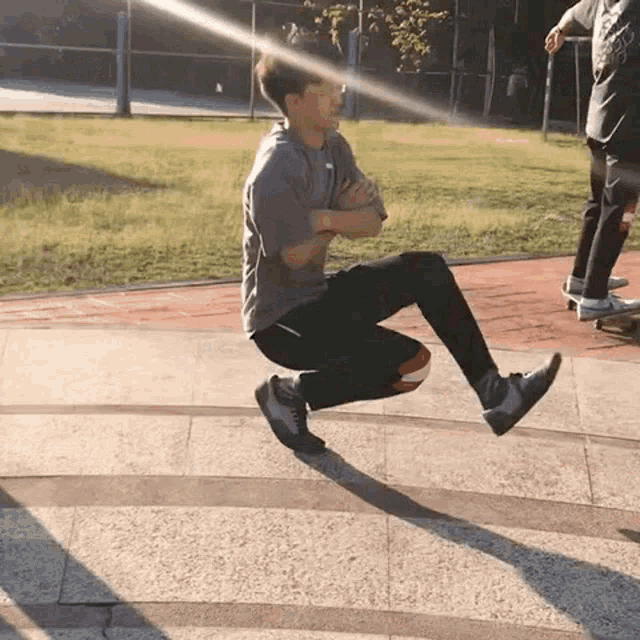a man is doing a trick on a skateboard while another man looks on .
