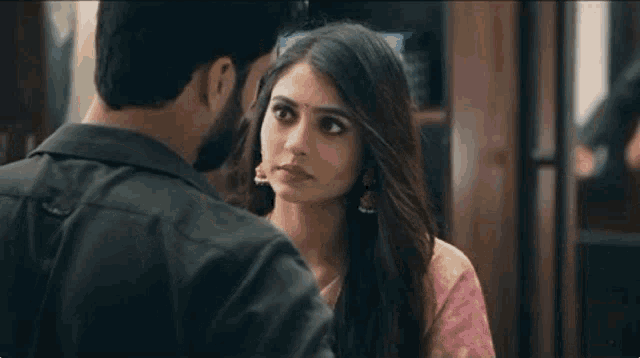 a man and a woman are looking at each other .